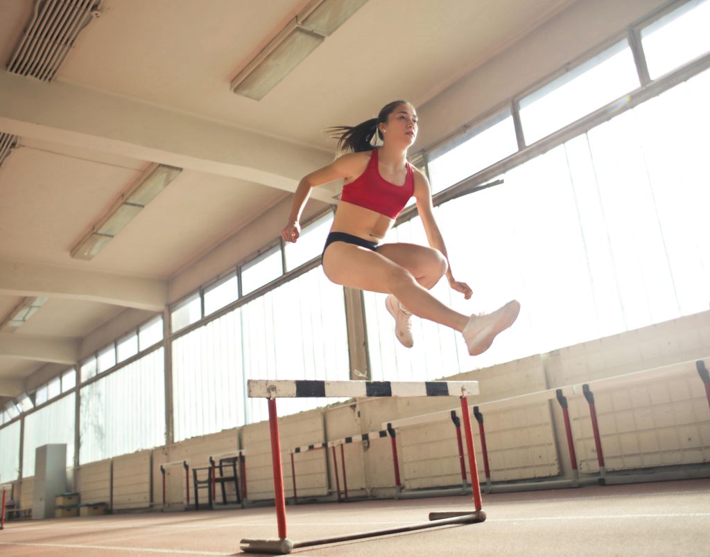 Girl jumping over hurdle Charlotte Acu Bodywork