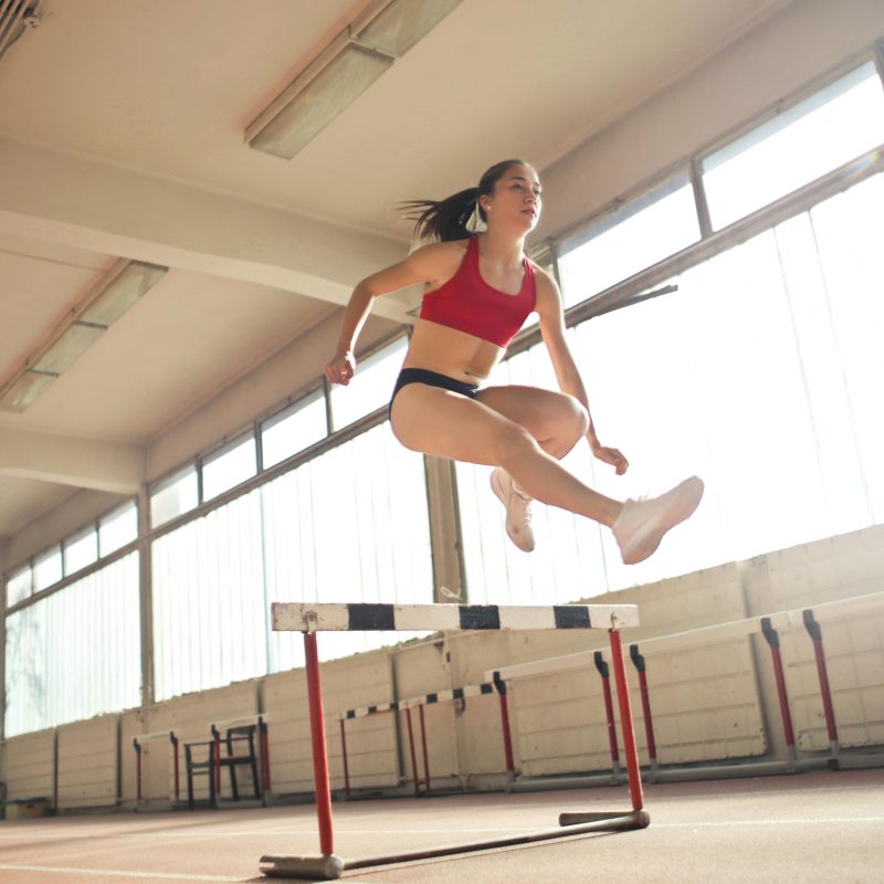 Girl jumping over hurdle Charlotte Acu Bodywork